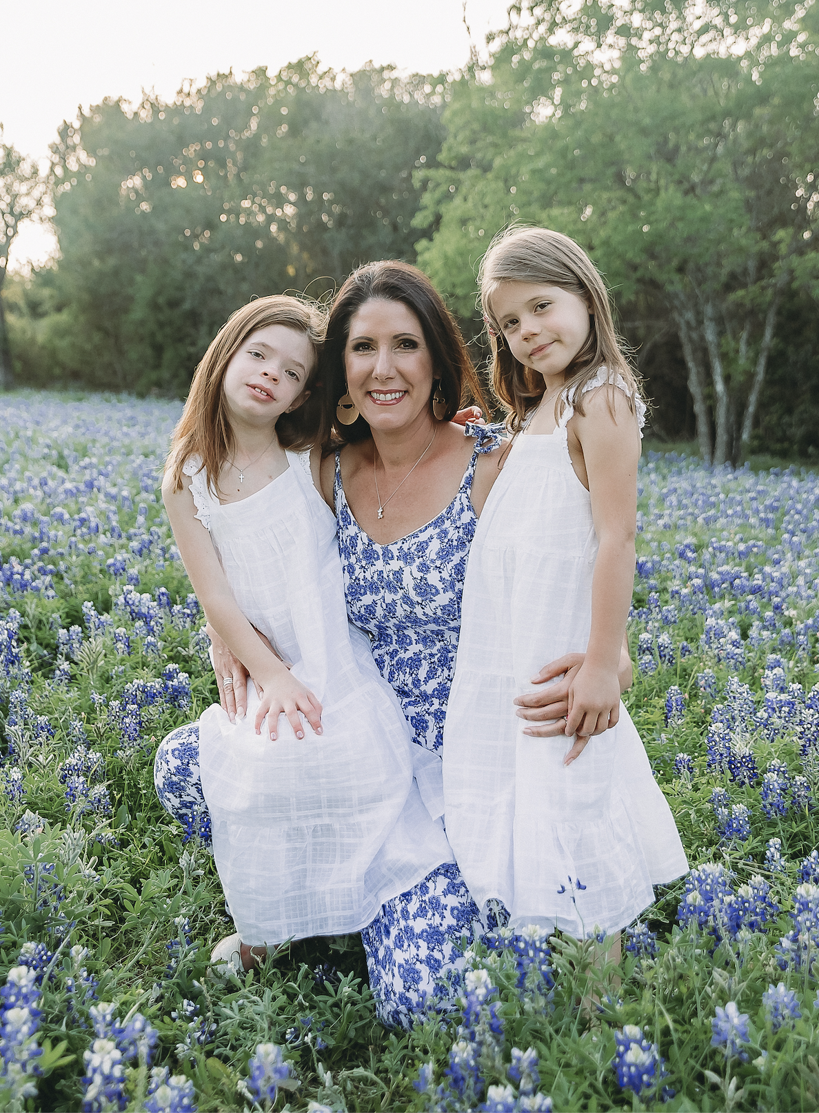 Heather, founder of Muralé, with her daughters Emma and Ellie in a Texas bluebonnet field.